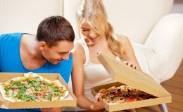romantic couple eating pizza at home